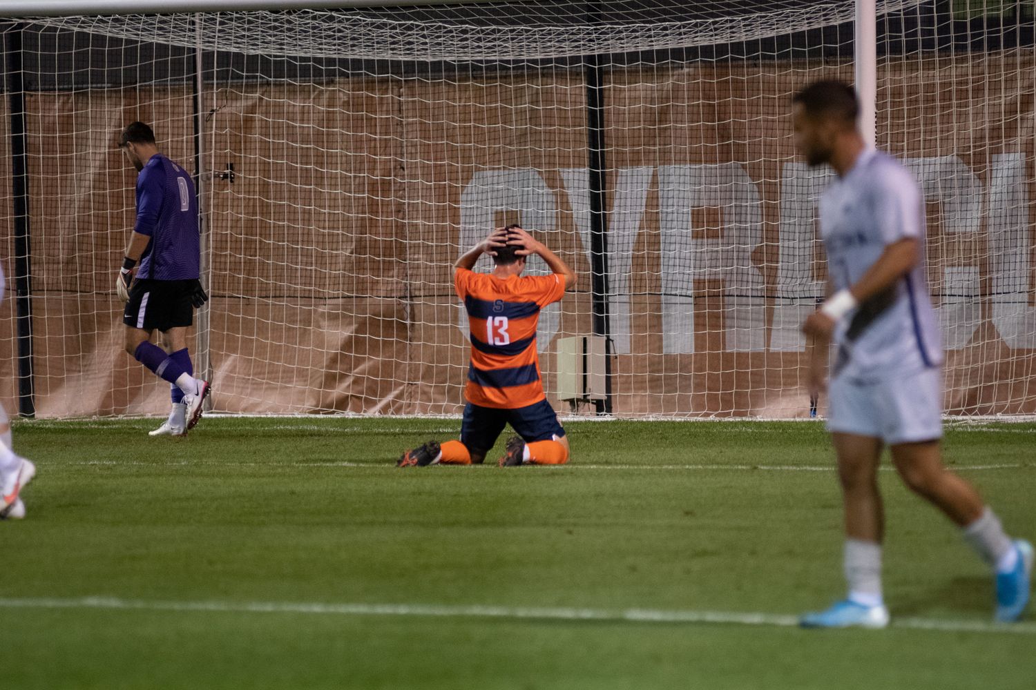 Syracuse's Colin Biros sits on his knees in front of the goal